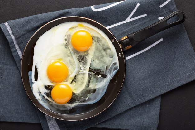 Photo fried eggs from three eggs in a pan