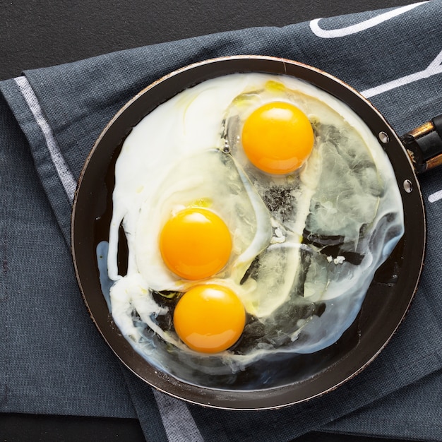 Photo fried eggs from three eggs in a pan