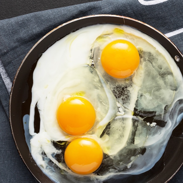 Photo fried eggs from three eggs in a pan