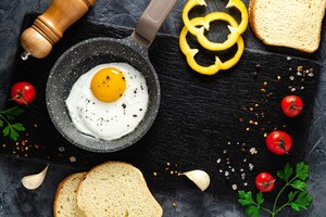 Fried eggs in a frying pan with fresh vegetables and spices. concept for menu and advertising.