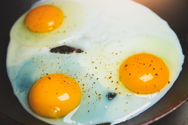 Photo fried eggs on the pan. organic orange yolks. breakfast idea.