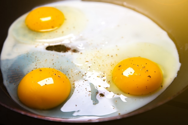 Fried eggs on the pan. Organic orange yolks. breakfast idea.