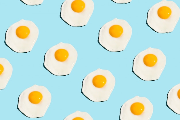 Fried eggs pattern on blue background