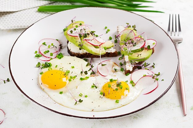 Fried eggs and sandwiches with avocado and radish for healthy breakfast