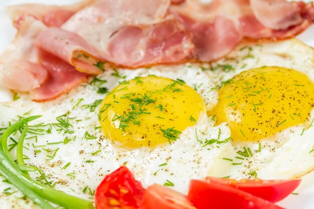 Fried eggs with bacon greens and tomatoes