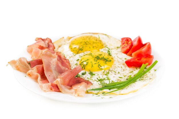 Fried eggs with bacon on a plate isolated on white background