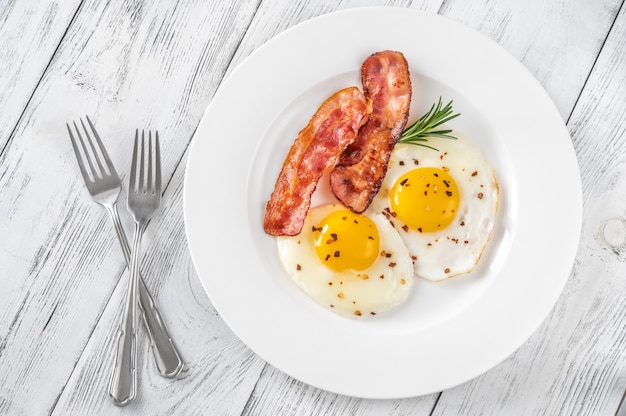 Fried eggs with bacon rashers  on the white plate