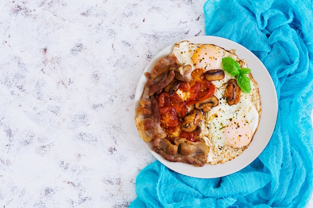 Fried eggs with bacon, tomatoes and mushrooms 