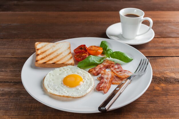 Fried eggs with bacon and vegetables