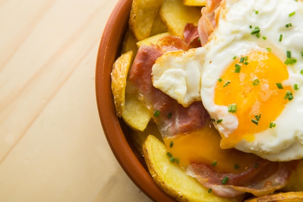 Photo fried eggs with chips and serrano ham traditional spanish tapa nicknamed huevos rotos