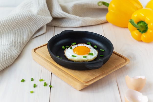 Fried eggs with green onions in a cast iron skillet