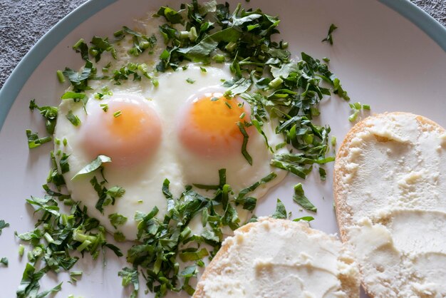 Fried eggs with greens closeup