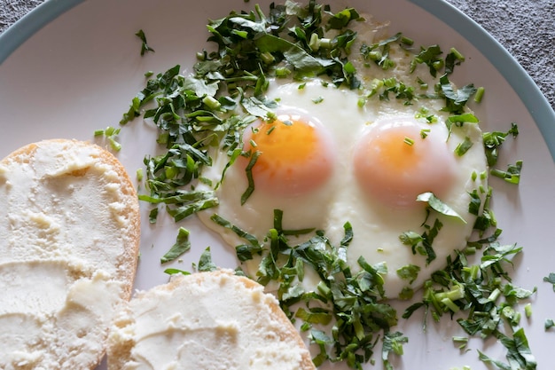 Fried eggs with greens closeup