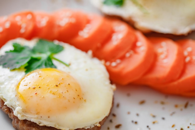Жареные яйца с мясными котлетами и морковью крупным планом, селективный фокус