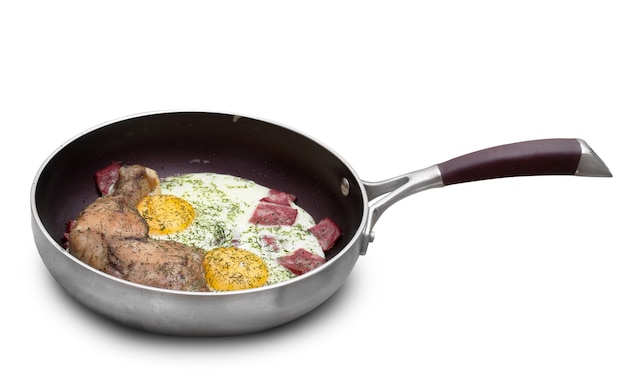 Жареные яйца с колбасой и куриной ножкой на сковороде. изолирован на белом фоне