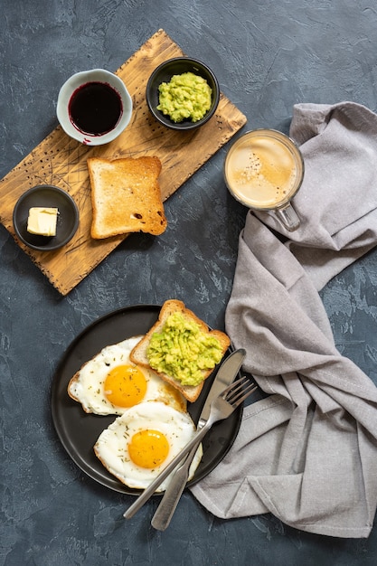 写真 トーストアボカドジャムとコーヒーマグの朝食のコンセプトと目玉焼きフラットレイおいしい朝食典型的なホテルの朝食