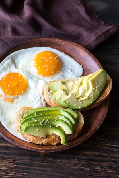 Fried eggs with toasts and avocado