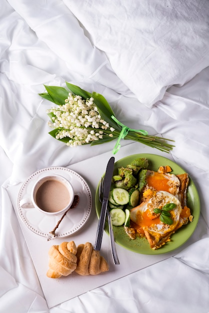 Fried eggs with toasts and tea in bed