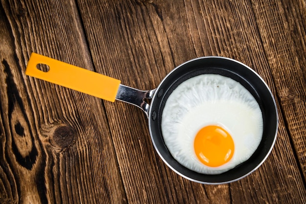 Photo fried eggs on wooden background