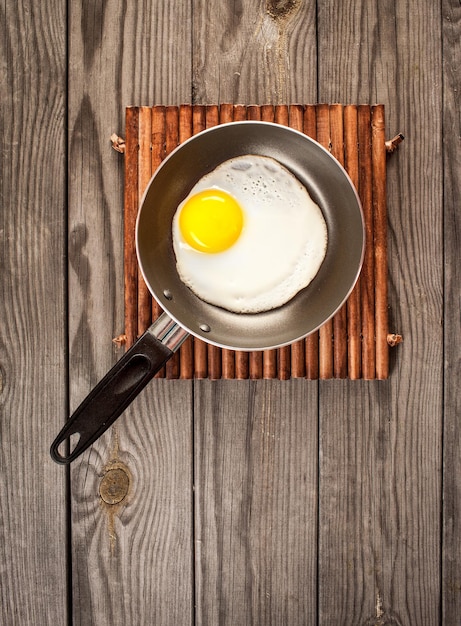 Fried eggs on a wooden table, breakfast