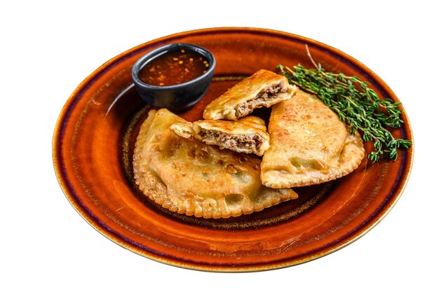 Fried empanadas with minced beef meat served on a plate with chili sauce Isolated on white background