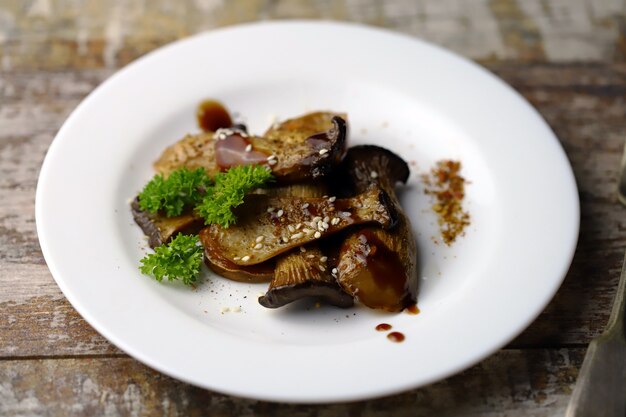 Fried eringi mushrooms, served on a white plate