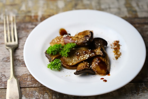 Fried eringi mushrooms, served on a white plate