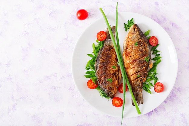 Carpa pesce fritto e insalata di verdure fresche.