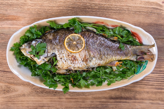 Carpa di pesce fritto nel piatto su legno