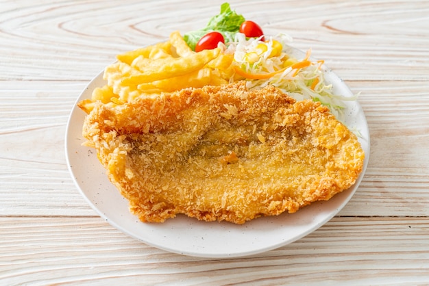 fried fish fillet and potatoes chips with mini salad