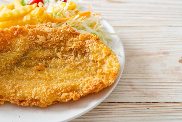 fried fish fillet and potatoes chips with mini salad