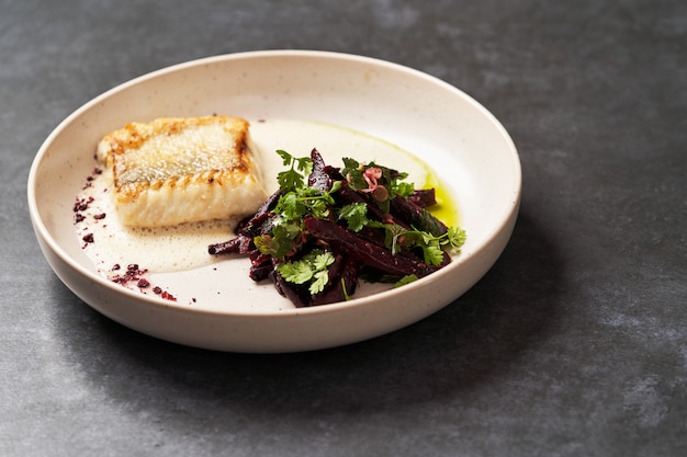 Fried fish perch with vegetables on a white table on grey table