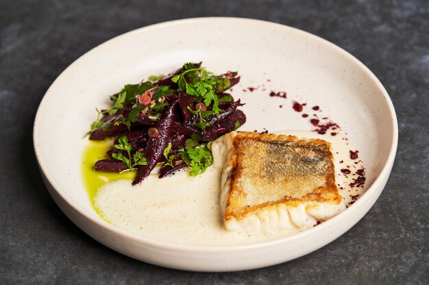 Fried fish perch with vegetables on a white table on grey table