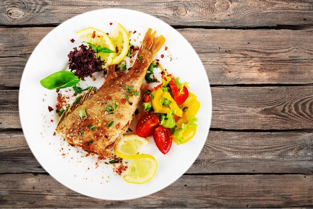 Fried fish on plate on background