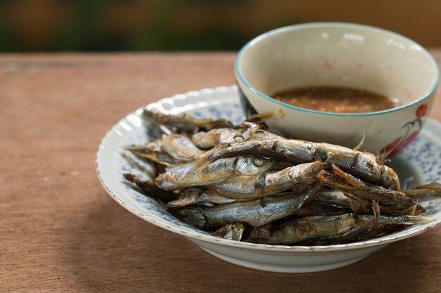 Fried fish on plate with wooden desk