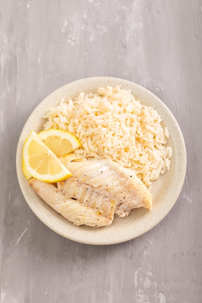 Fried fish with boiled white rice on white dish