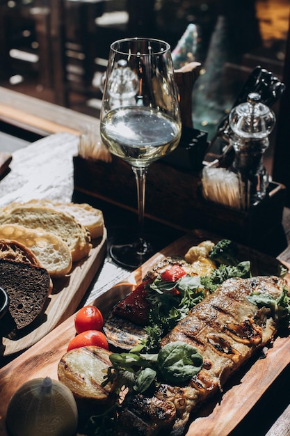 Foto pesce fritto con verdure alla griglia su uno stand di legno che serve un ristorante