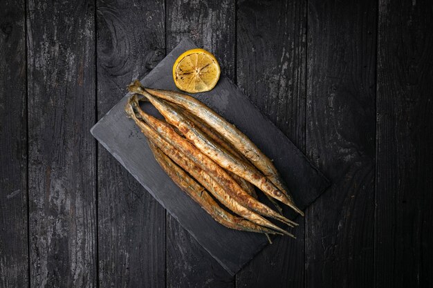 Fried fish with lemon on a dark table