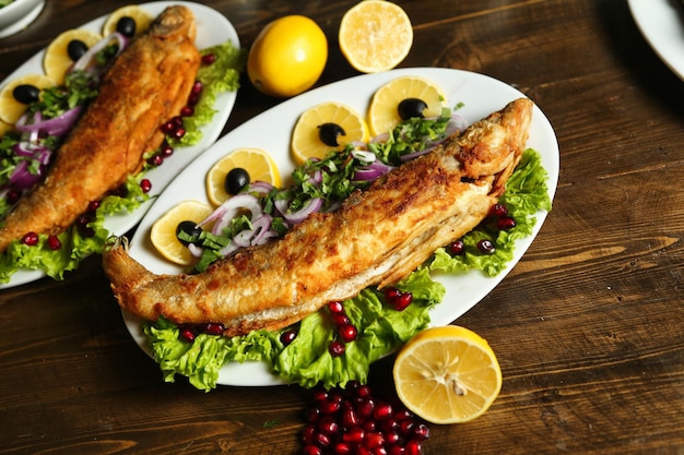 木製のテーブルでレモンとナツメヤモリで揚げた魚