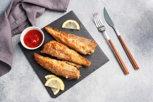 Fried fish with tomato sauce and lemon