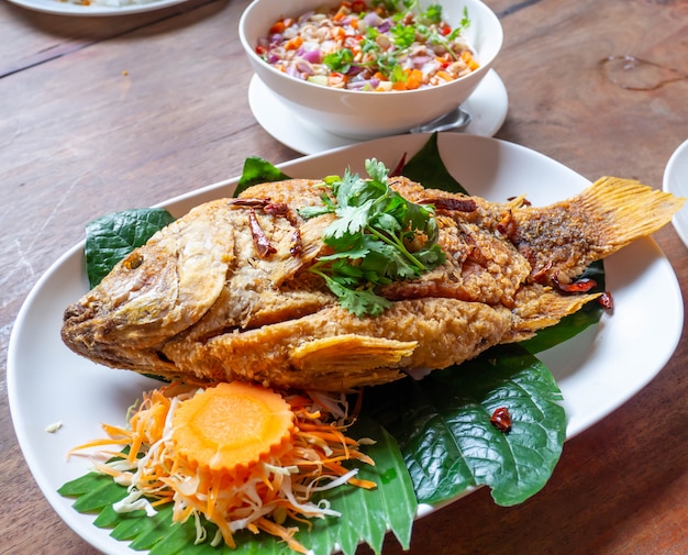 fried fish with vegetable on white dish.