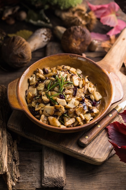 Fried forest mushrooms, boletus, onions. Rustic dish in a frying pan, vegetarian autumn food on top of view