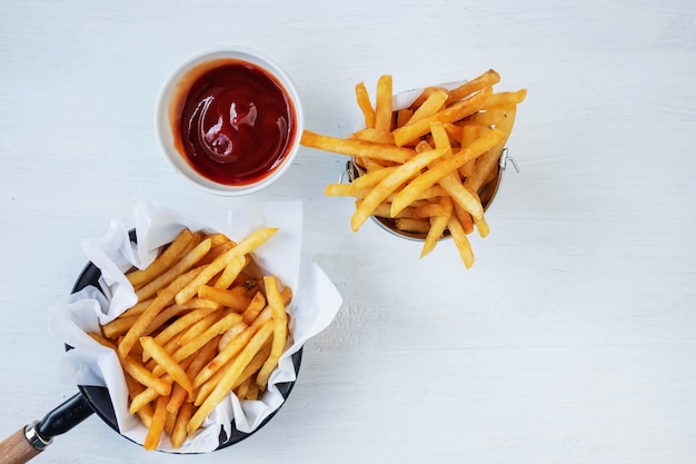 Fried french fries and ketchup with soft drinks on a table