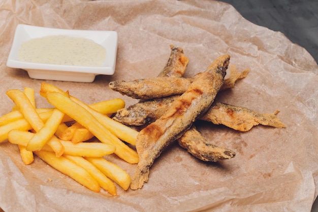 Fried French fries on a plate on the wooden table