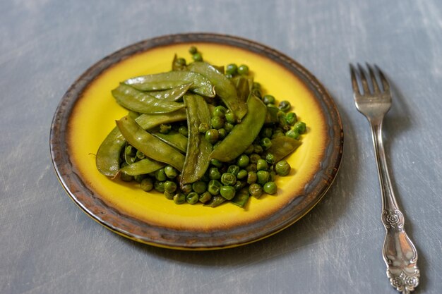 Fried green peas on a ceramic yellow plate