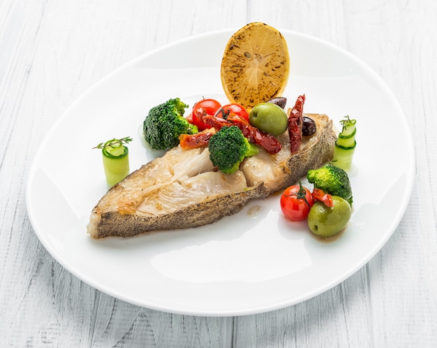 Fried halibut with vegetables and mustard, on the plate