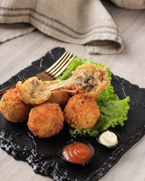 Photo fried homemade dutch bitterballen with spicy sauce and mayonaise filled with mushroom