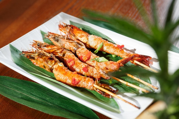 Fried hot big size shrimps  on sticks served on a plate