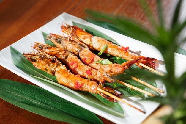 Fried hot big size shrimps on sticks served on a plate