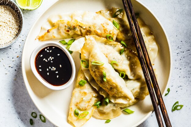 Fried Korean-bollen met groene ui en saus op witte plaat, hoogste mening.